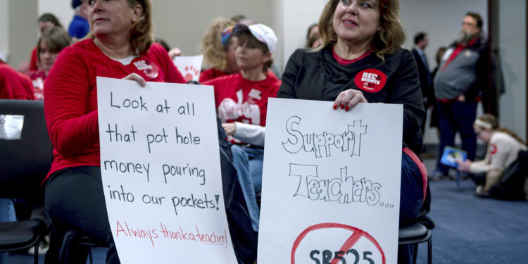 Kristin Walker, a Jefferson County teacher sits in a hearing room waiting to protest the passage of a bill that would change how individuals are nominated to the Kentucky teachers retirement systems board of trustees, in Frankfort,, Ky, Thursday, Feb. 28, 2019. (AP Photo/Bryan Woolston)