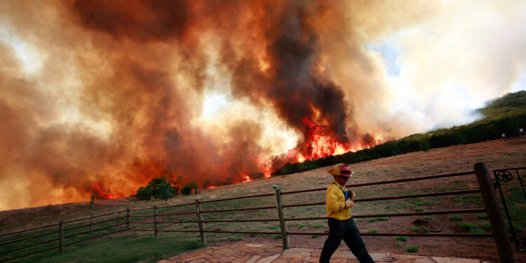 STRAWN, TX - APRIL 19:  Emergency crews battle a running wildfire that is threatning a home on April 19, 2011 in Strawn, Texas. Dozens of area homes have been destroyed in the wildfires that have been fueled by dry conditions, high winds, and low humidity.  (Photo by Tom Pennington/Getty Images)