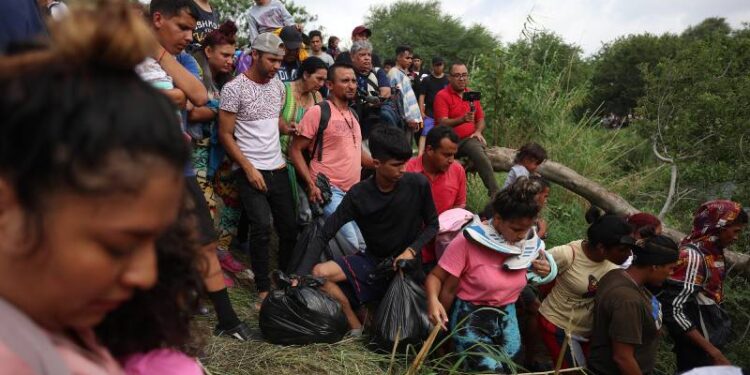 MATAMOROS, MEXICO - MAY 11: Migrants walk into the Rio Grande from the bank of the river as they cross to enter the United States on May 11, 2023 in Matamoros, Mexico. A surge of migrants is expected with the end of the U.S. government's Covid-era Title 42 policy, which for the past three years has allowed for the quick expulsion of irregular migrants entering the country.   Joe Raedle/Getty Images/AFP (Photo by JOE RAEDLE / GETTY IMAGES NORTH AMERICA / Getty Images via AFP)