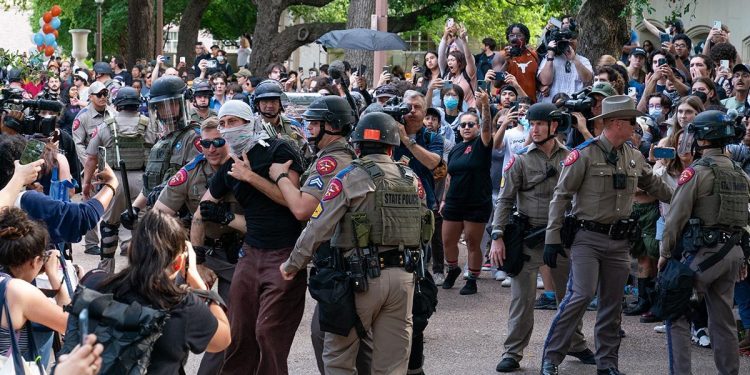 A person is detained by police as pro-Palestinian students protest the Israel-Hamas war on the campus of the University of Texas in Austin, Texas, on April 24, 2024. Universities have become the focus of intense cultural debate in the United States since the October 7 Hamas attack and Israel's overwhelming military response to it. (Photo by SUZANNE CORDEIRO / AFP)